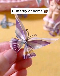 someone is holding a paper butterfly in front of the camera and texting, butterflies at home