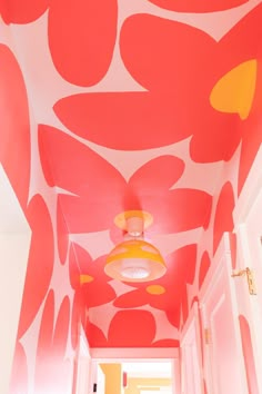 the hallway is painted in bright pink and orange colors with an interesting flower pattern on the ceiling