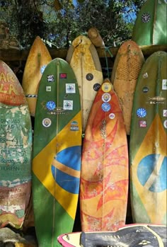 several surfboards are lined up against a wall