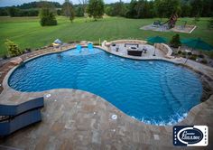 an outdoor swimming pool surrounded by lawn furniture