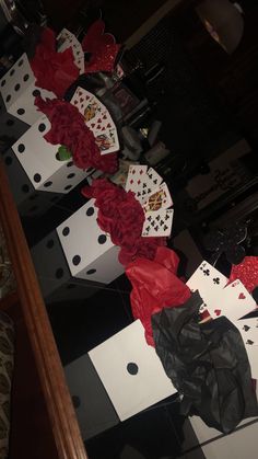 the table is decorated with red roses and playing cards