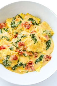 an omelet with spinach and tomatoes in a white bowl