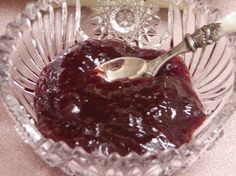 a glass bowl filled with jelly and a spoon