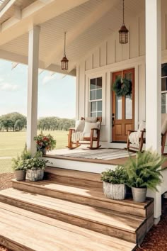 a porch with wooden steps and potted plants on the front step next to it