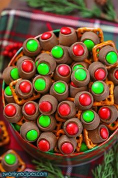 christmas pretzels in a bowl with green and red candies on top, sitting on a plaid tablecloth