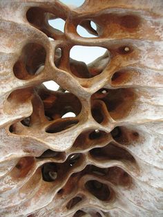 an intricately carved piece of wood with holes in it