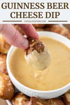 a person dipping some kind of cheese dip into a bowl with bread rolls in the background