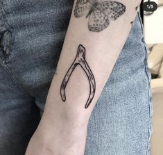 a person with a tattoo on their arm holding a pair of scissors in front of a butterfly