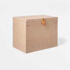 an empty cardboard box sitting on top of a white surface with a brown leather handle