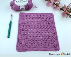 a purple crochet square next to a ball of yarn