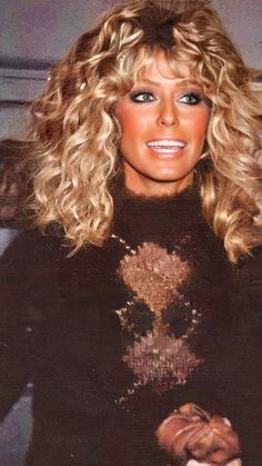 a woman with blonde hair wearing a black sweater