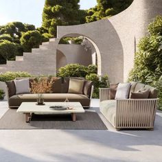 a living room filled with lots of furniture next to a stone wall covered in greenery