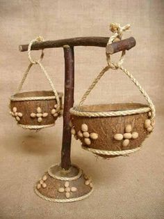 an old wooden balance scale with balls hanging from it's sides and ropes on top