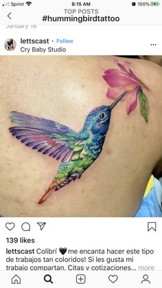 the back of a woman's stomach with a colorful hummingbird tattoo on it