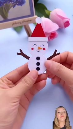 a person holding a snowman ornament in their hands