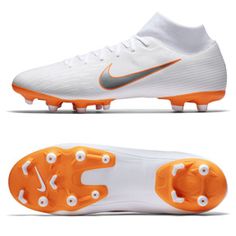 a pair of white and orange soccer cleats with the word nike written on it