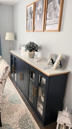 a living room with a couch, sideboard and pictures on the wall