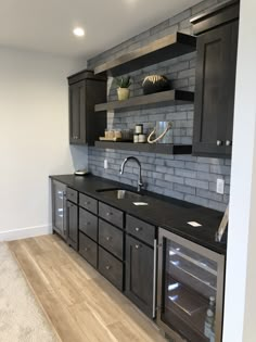 a kitchen with black cabinets and stainless steel appliances