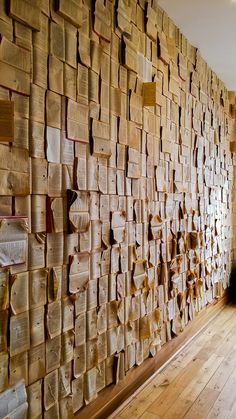 there is a large wall made out of old papers on the wall and wood floors