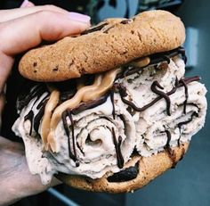 a person holding a cookie ice cream sandwich