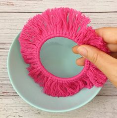 a person is holding a pink duster on a blue plate