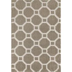 an area rug with grey and white geometric designs on the front, along with a light brown