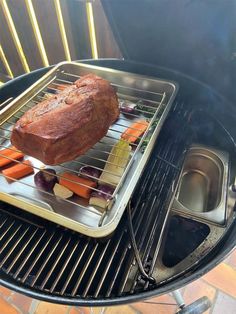 a roasting rack with carrots, onions and meat cooking on top of it