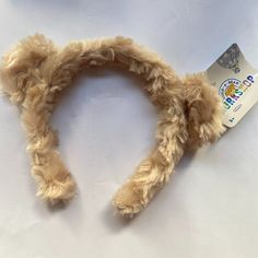 a teddy bear's ears and tail laying on a white surface with a package