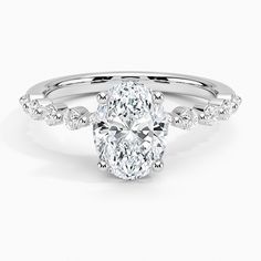 an oval shaped diamond ring with pave set shoulders