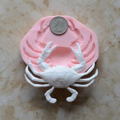 a coin sitting on top of a plastic crab