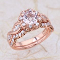 an engagement ring set with a large diamond center surrounded by smaller diamonds on top of it