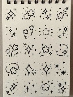 a white notebook with black and white doodles on the pages, which are drawn in different