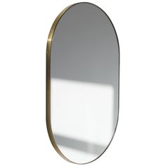 an oval mirror with a gold frame on a white background