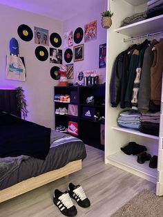 a bedroom with clothes and shoes on the floor in front of a wall mounted record player