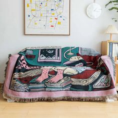 a couch covered in a colorful blanket next to a clock