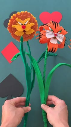 someone is holding up some paper flowers to make it look like they are made out of construction paper