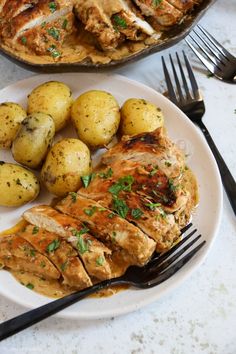 two plates with chicken and potatoes on them