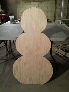 a wooden sculpture sitting on top of a table next to a gray table with chairs