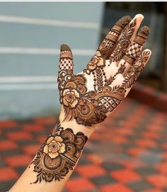 a woman's hand is decorated with hennap and flowers on the palm