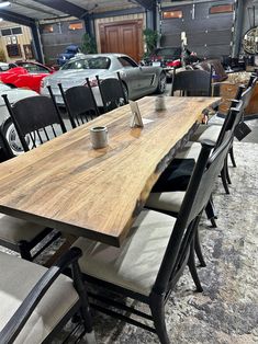 a long table with chairs around it in a room filled with cars and other items