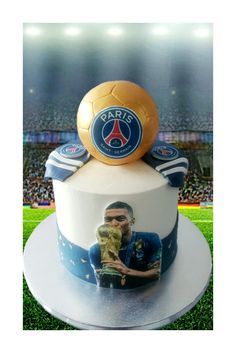 a soccer ball on top of a cake with the image of a man holding a soccer ball