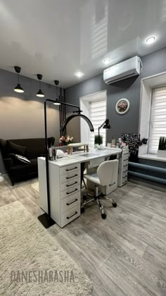 a white desk sitting on top of a hard wood floor next to a chair and window