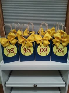 four bags with bows are sitting on a shelf in front of a window, decorated with the number eighteen