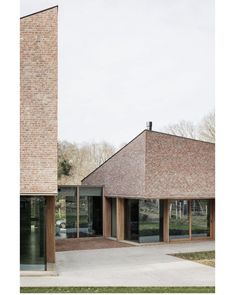 two large brick buildings sitting next to each other on top of a grass covered field