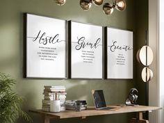 three framed art prints on the wall above a desk with a laptop and other items