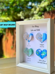 a white frame with three heart shaped paper cut outs in it and the words give and gift