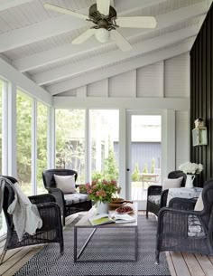 a living room filled with furniture and a ceiling fan in the middle of an open floor plan