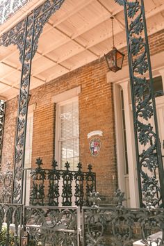 an ornate iron balcony and railing on a brick building