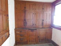 an empty room with wooden cupboards and windows