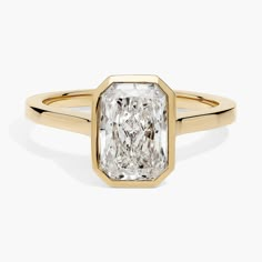 a yellow gold engagement ring with an oval cut diamond in the center, on a white background